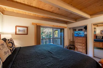 a bedroom with a large bed and a television at Creekside Chalet Stay for 6 in Kings Beach