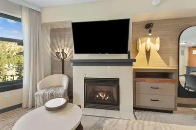 a living room with a fireplace with a flat screen tv at Hillside #508 - Cozy Studio w King Bed Fireplace & Kitchenette in Mammoth Lakes