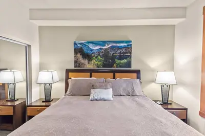 a bedroom with a large bed with two lamps at The Village #2408 - Village Center Cozy Getaway w Fireplace in Mammoth Lakes
