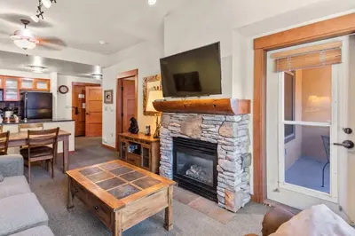 a living room with a fireplace and a tv at The Village #2408 - Village Center Cozy Getaway w Fireplace in Mammoth Lakes