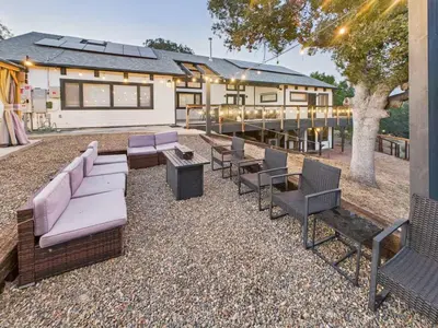 a patio with couches and chairs in front of a house at Hilltop Luxury Yosemite Retreat with Spa, Pool, Views in Mariposa