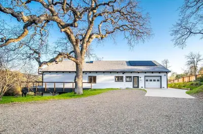 a white house with a tree in front of it at Hilltop Luxury Yosemite Retreat with Spa, Pool, Views in Mariposa