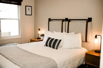 a bedroom with a white bed with a black and white pillow at Family Getaway Near Yosemite - Downtown Mariposa in Mariposa