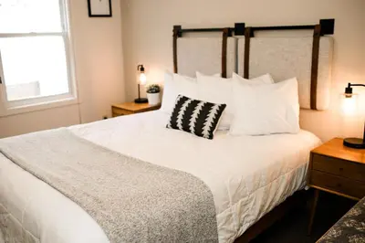 a bedroom with a white bed with a black and white pillow at Family Getaway Near Yosemite - Downtown Mariposa in Mariposa