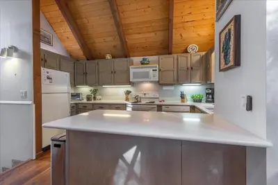 a kitchen with a white counter top and wooden ceilings at Martis Landing home in Truckee