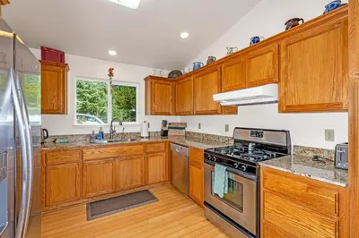a kitchen with wooden cabinets and a stove top oven at Yosemite Terrace View Retreat in Mariposa