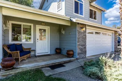 a front porch of a house with a blue couch at Yosemite Terrace View Retreat in Mariposa