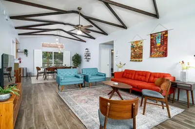 a living room with a red couch and blue chairs at Serenity Pines 1hr to Yosemite w BBQ and Game Room in Mariposa