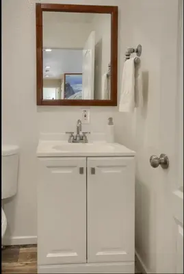 a white bathroom with a sink and a mirror at Hillside Bungalow - Walking distance to downtown in Mariposa