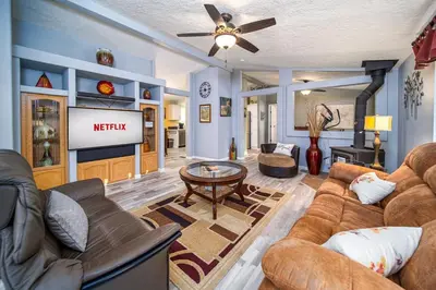 a living room with a couch and a table at The Nest-2 K Beds-Game Room-Deck-5 min to Mariposa in Mariposa