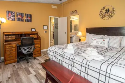 a bedroom with a bed with a desk and a chair at The Nest-2 K Beds-Game Room-Deck-5 min to Mariposa in Mariposa