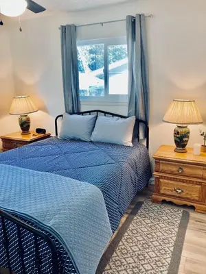 a bedroom with a blue bed and a window at Ely Farm House - Near Yosemite National Park in Oakhurst