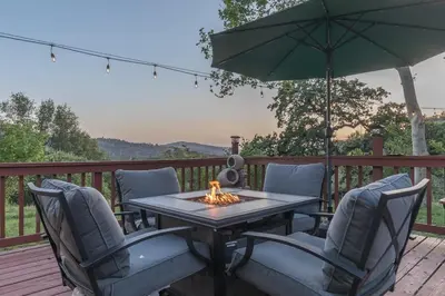 a table with chairs and an umbrella on a deck at Sullivan House & SPA Near Yosemite, 8 Min to Town in Mariposa
