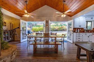 a dining room with a table and a kitchen at Kindred Spirits Lodge near Yosemite & Bass Lake! in Oakhurst