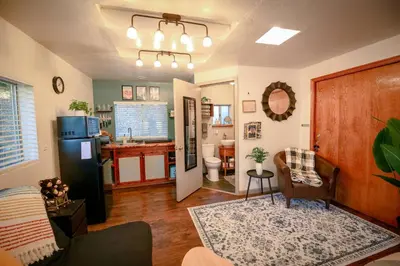 a living room with a refrigerator and a kitchen at Cozy Cabin Near Yosemite & Corlieu Falls in Oakhurst