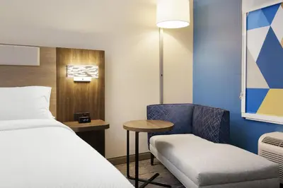 a room with a bed and a chair and a table at Holiday Inn Express & Suites Sparks Reno East by IHG in Sparks
