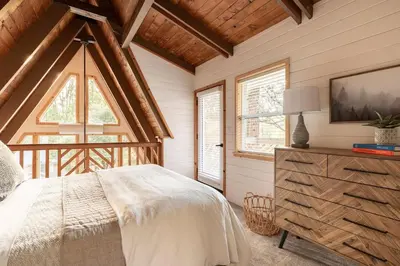a bedroom with a bed and a large window at Acorn Falls, Bass Lake, Ca in Bass Lake