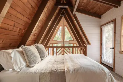 a bedroom with a bed with a large window at Acorn Falls, Bass Lake, Ca in Bass Lake