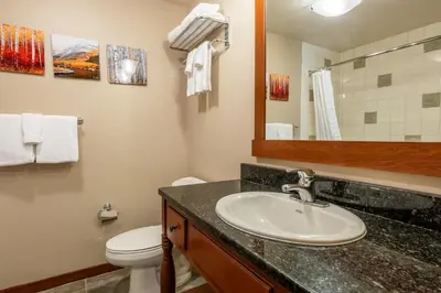 a bathroom with a sink and a toilet and a mirror at Village 1209 in Mammoth Lakes