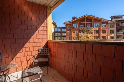 a balcony with a bench and a building in the background at Village 1209 in Mammoth Lakes