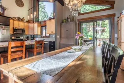 a kitchen with a long wooden table and chairs at Boathouse in the Woods by Tahoe Getaways - Minutes to Lake Tahoe & Northstar in Kings Beach