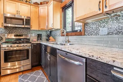 a kitchen with stainless steel appliances and wooden cabinets at Boathouse in the Woods by Tahoe Getaways - Minutes to Lake Tahoe & Northstar in Kings Beach