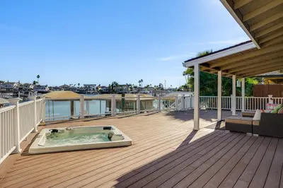 a patio with a hot tub on a deck at 5 Min to Fast Water Waterfront Discovery Bay Home in Discovery Bay