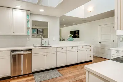 a white kitchen with white cabinets and a sink at 5 Min to Fast Water Waterfront Discovery Bay Home in Discovery Bay