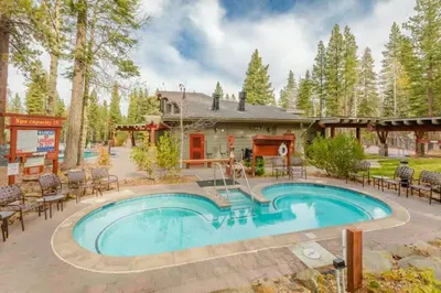 a house with a swimming pool in front of a house at Northstar Resort 2BR Condo with Rec Center Access in Truckee