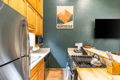 a kitchen with a stainless steel refrigerator and wooden cabinets at Northstar Resort 2BR Condo with Rec Center Access in Truckee