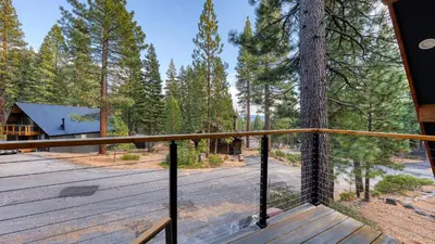 a view from the deck of a cabin with a tree at Retreat with Lake Access Deck Modern Interior Agate Peak by Avantstay in Carnelian Bay