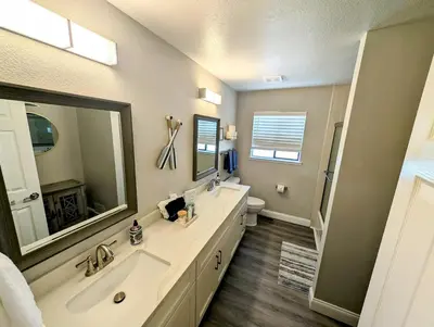 a bathroom with a sink and a mirror and a toilet at 3 Bedrooms - Game Room - On the water in Discovery Bay
