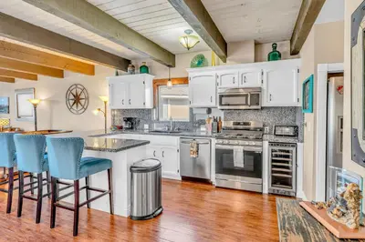 a kitchen with white cabinets and blue bar stools at South Lake Retreat Deck Dock & Game Table in South Lake Tahoe