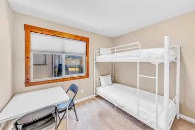 a room with two bunk beds and a desk and a window at South Lake Retreat Deck Dock & Game Table in South Lake Tahoe