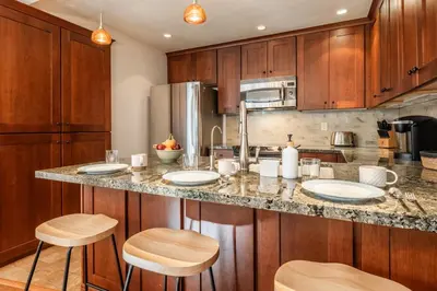 a kitchen with wooden cabinets and a counter with stools at St Moritz 38 in Mammoth Lakes