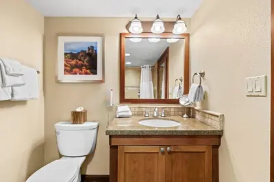 a bathroom with a toilet and a sink with a mirror at 6th Floor Mountain View Room - Fireplace Suite in Tahoe City