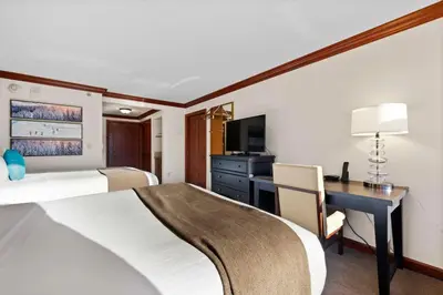 a hotel room with a bed and a desk with a computer at 6th Floor Mountain View Room - Fireplace Suite in Tahoe City