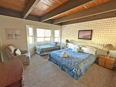 a bedroom with a bed and a chair and a couch at 439 Ala Wai, 119 condo in South Lake Tahoe