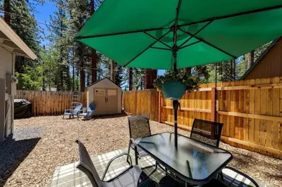 a table with a green umbrella in a backyard at 3300 Cape Horn home in South Lake Tahoe