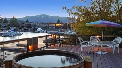 a deck with a table and chairs and an umbrella at 1673 Venice Drive home in South Lake Tahoe