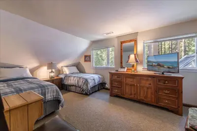 a bedroom with two beds and a flat screen tv at Fred's Retreat cabin in Homewood