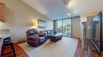 a living room with a leather couch and a table at Snowcreek V #1002 condo in Mammoth Lakes