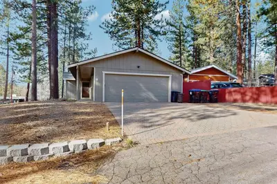 a house with a garage and a driveway at Mid-Century Tahoe Ranch House in South Lake Tahoe