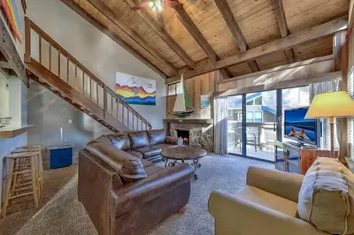 a living room with a leather couch and a table at Lakefront Townhome in South Lake Tahoe in South Lake Tahoe