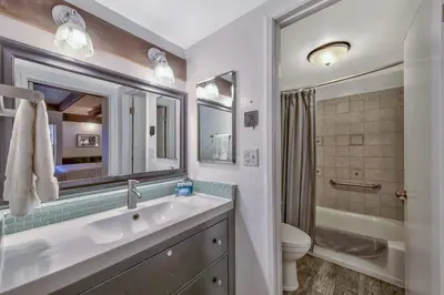 a bathroom with a sink and a toilet and a mirror at Lakefront Townhome in South Lake Tahoe in South Lake Tahoe
