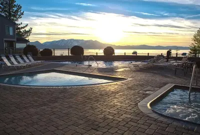 a swimming pool with a sunset in the background at Lakefront Townhome in South Lake Tahoe in South Lake Tahoe