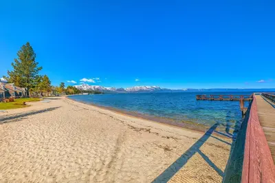 a view of a beach with mountains in the background at Lakefront Townhome in South Lake Tahoe in South Lake Tahoe