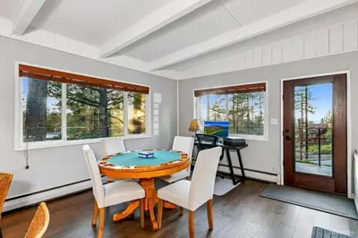 a dining room with a table and chairs and windows at 3748 Terrace Drive home in South Lake Tahoe