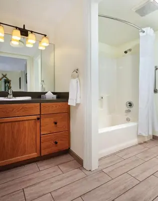 a bathroom with a large mirror and a sink and a tub at Wyndham Angels Camp- 1 BR- Apartment with Resort Access in Angels Camp