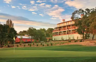 a golf course with a hotel in the background at Wyndham Angels Camp- 1 BR- Apartment with Resort Access in Angels Camp